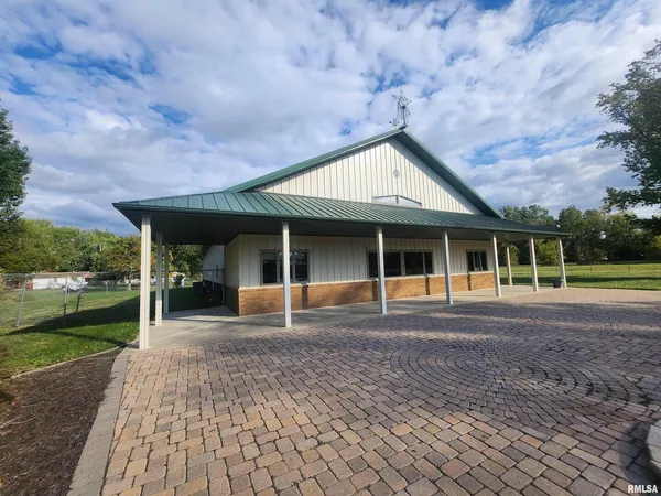 a front view of a house with a garden and trees