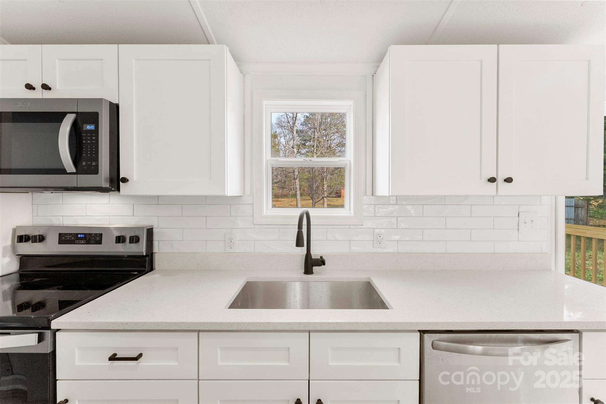 226 Muldoon Lane Clover, SC 29710 - Photo 11 of 31 a kitchen with white cabinets a sink and a stove with wooden floor