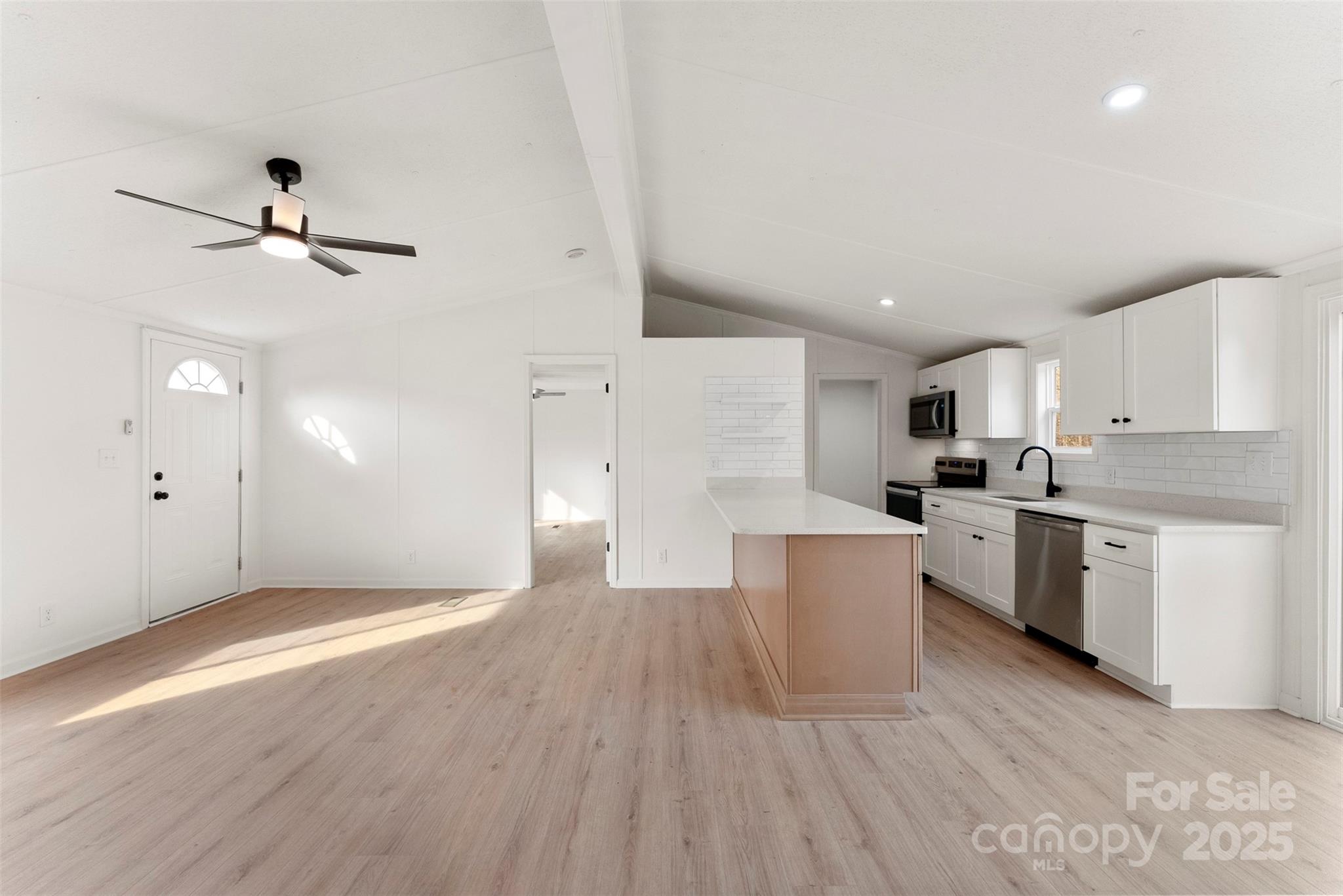 226 Muldoon Lane Clover, SC 29710 - Photo 6 of 31 a large kitchen with cabinets wooden floor and stainless steel appliances