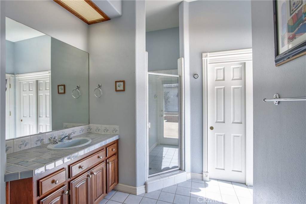 46856 El Prado Road Temecula, CA 92590 - Photo 48 of 75 a bathroom with a granite countertop sink and a mirror