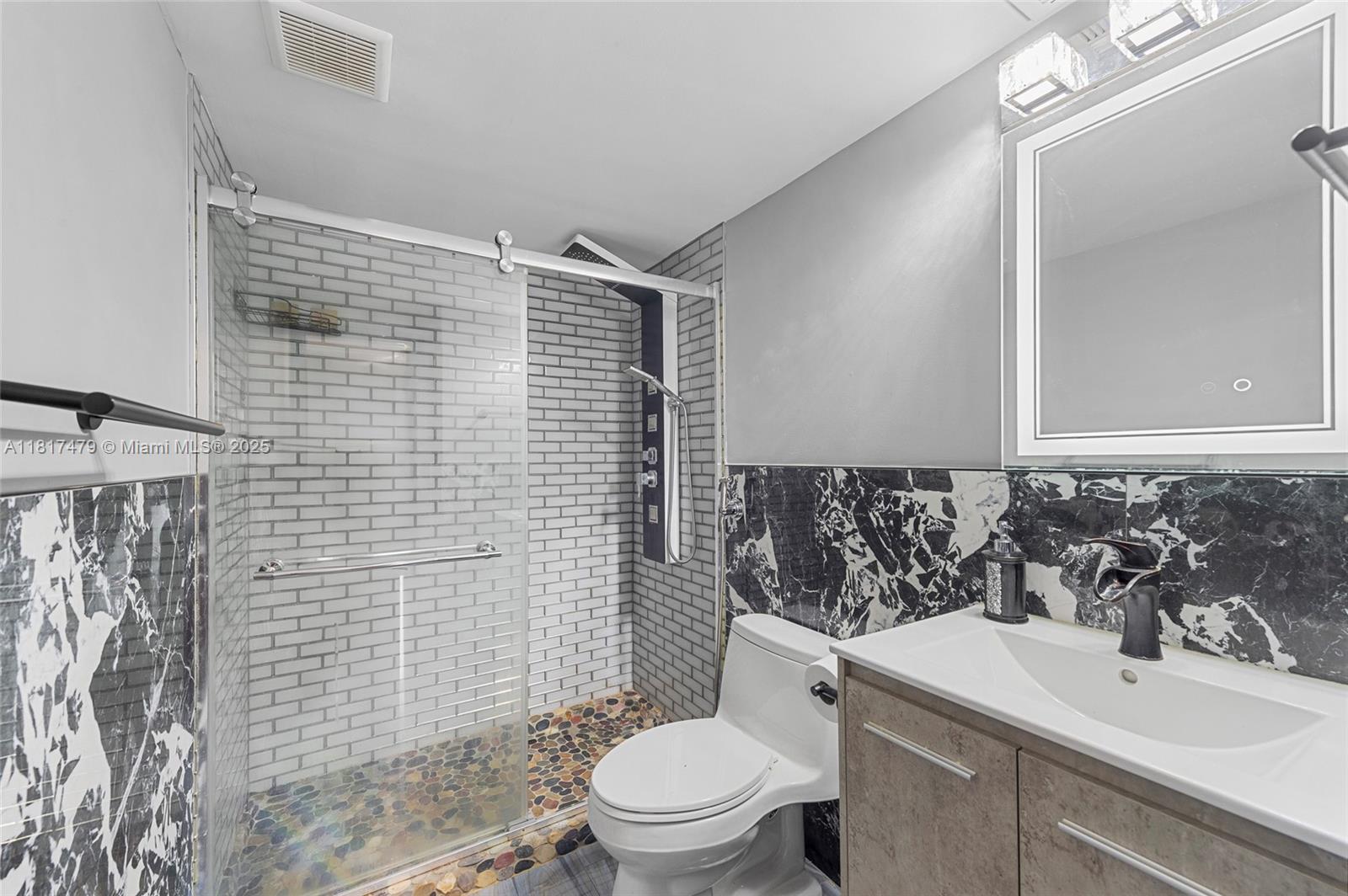 1345 Lincoln Road, Unit 1105 Miami Beach, FL 33139 - Photo 10 of 25 a bathroom with a sink a toilet and shower