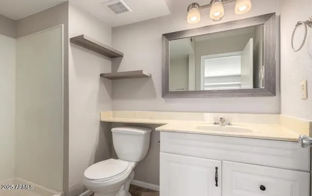 a bathroom with a toilet sink and mirror