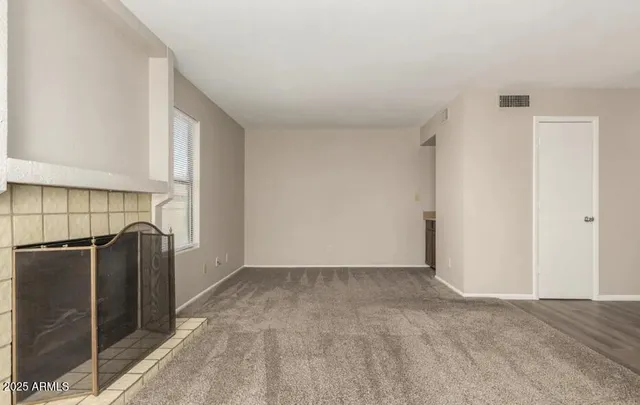a view of a refrigerator in kitchen and an empty room