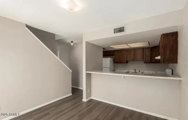 a view of a kitchen with a sink and wooden floor