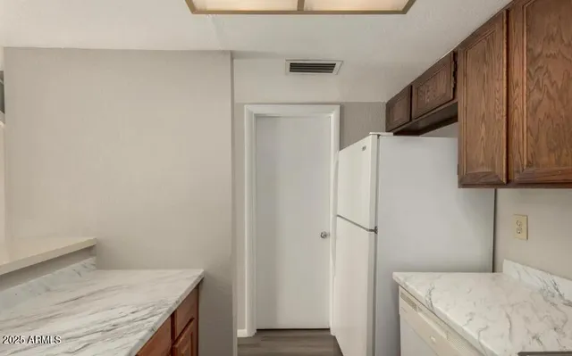 a kitchen with a refrigerator and a stove top oven