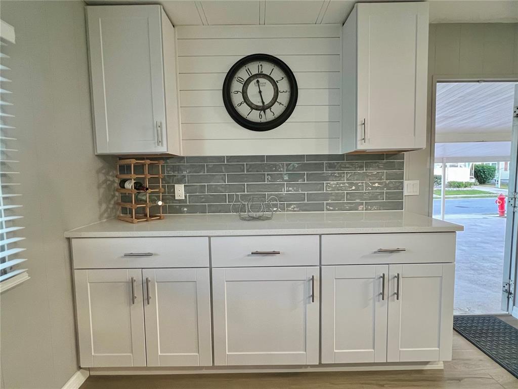 1100 South Belcher Road, Unit 469 Largo, FL 33771 - Photo 12 of 69 a view of granite countertop white cabinets with a clock on the wall