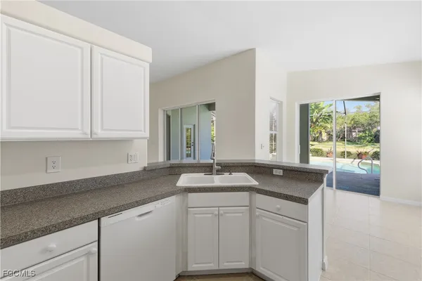 a kitchen with granite countertop a sink a stove and cabinets