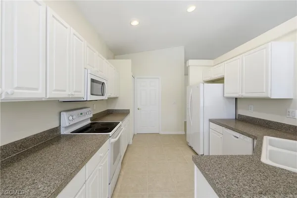 a kitchen with stainless steel appliances granite countertop a refrigerator sink and cabinets