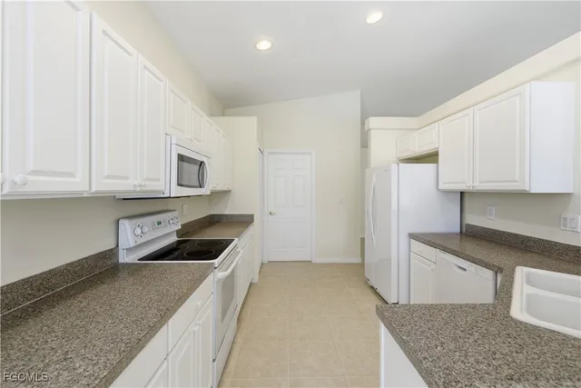 a kitchen with stainless steel appliances granite countertop a refrigerator sink and cabinets