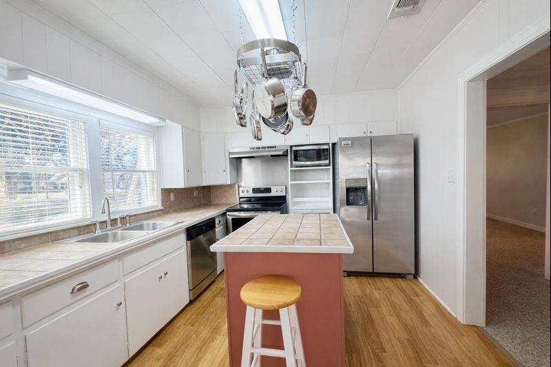 1505 Bonham Street Commerce, TX 75428 - Photo 11 of 39 Kitchen with plentiful counter and cabinet space, island and pot hanger