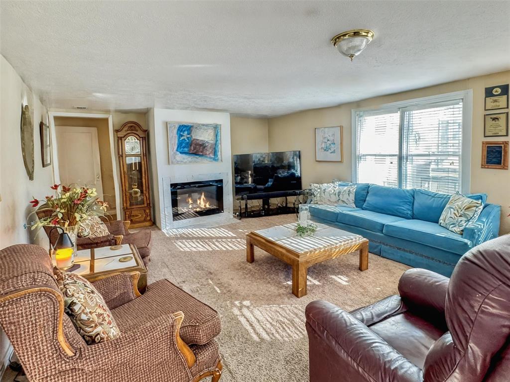 1505 Bonham Street Commerce, TX 75428 - Photo 29 of 39 Spacious secondary living room with a gas fireplace that has been changed to an electric fireplace. Fireplace virtually enchanced