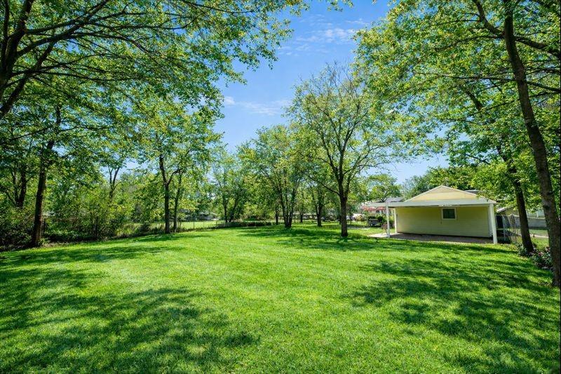 1505 Bonham Street Commerce, TX 75428 - Photo 34 of 39 Large lot with attached garage, carport, and outdoor cooking area. Grass and trees digitally enhanced to show seasonal potential