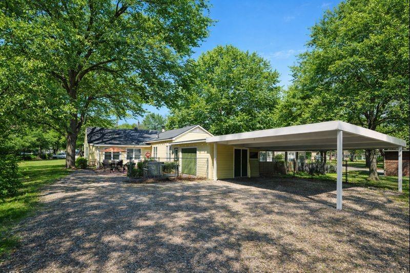 1505 Bonham Street Commerce, TX 75428 - Photo 35 of 39 Large lot with attached garage, carport, and outdoor cooking area. Grass and trees digitally enhanced to show seasonal potential