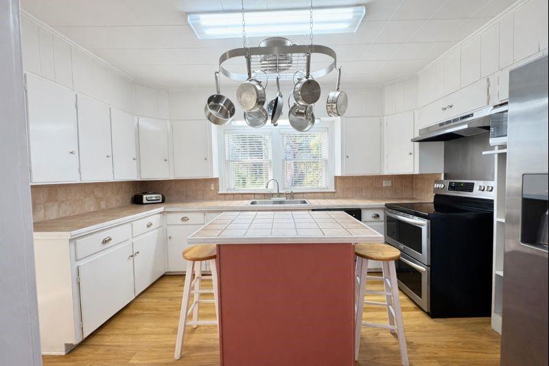 1505 Bonham Street Commerce, TX 75428 - Photo 10 of 39 Kitchen with plentiful counter and cabinet space, island and pot hanger