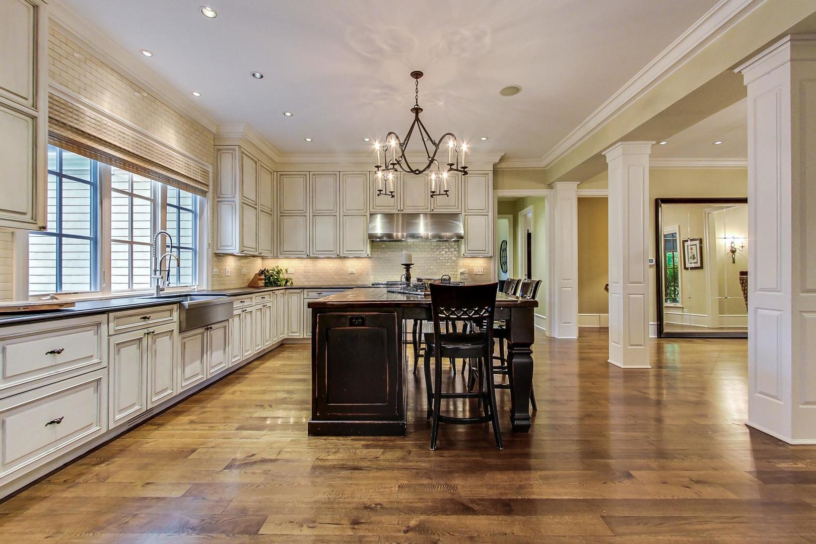 701 Plamondon Road Wheaton, IL 60189 - Photo 16 of 79 a kitchen with stainless steel appliances kitchen island granite countertop a stove a sink and a dining table with wooden floor