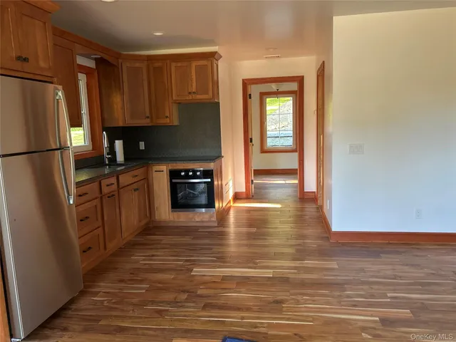 a kitchen with granite countertop a refrigerator stove top oven and sink
