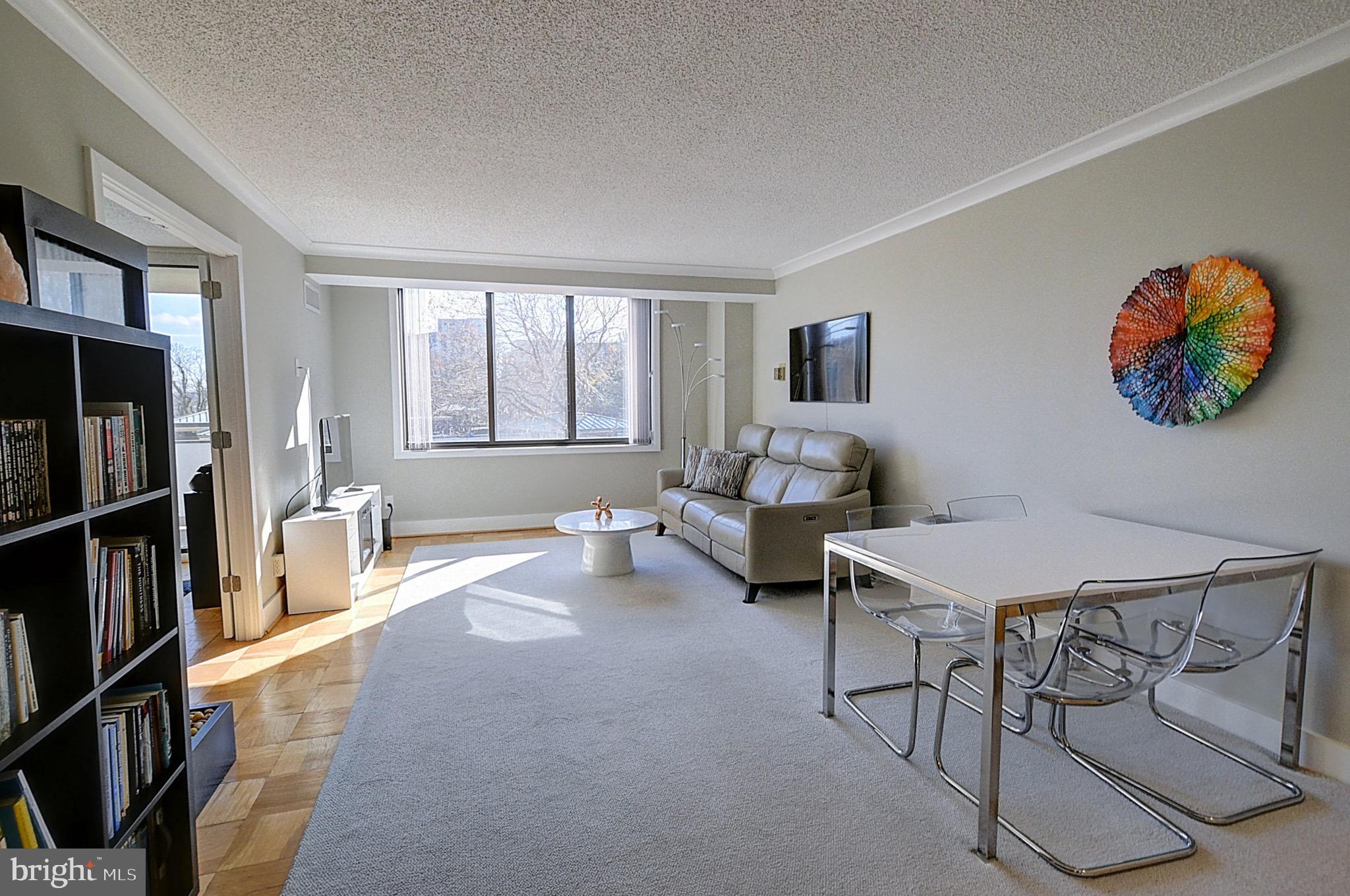 a living room with furniture a window and a flat screen tv