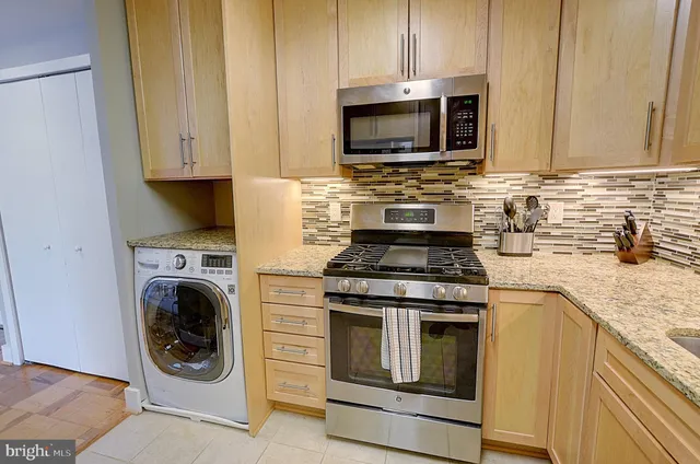 a kitchen with microwave a stove and cabinets