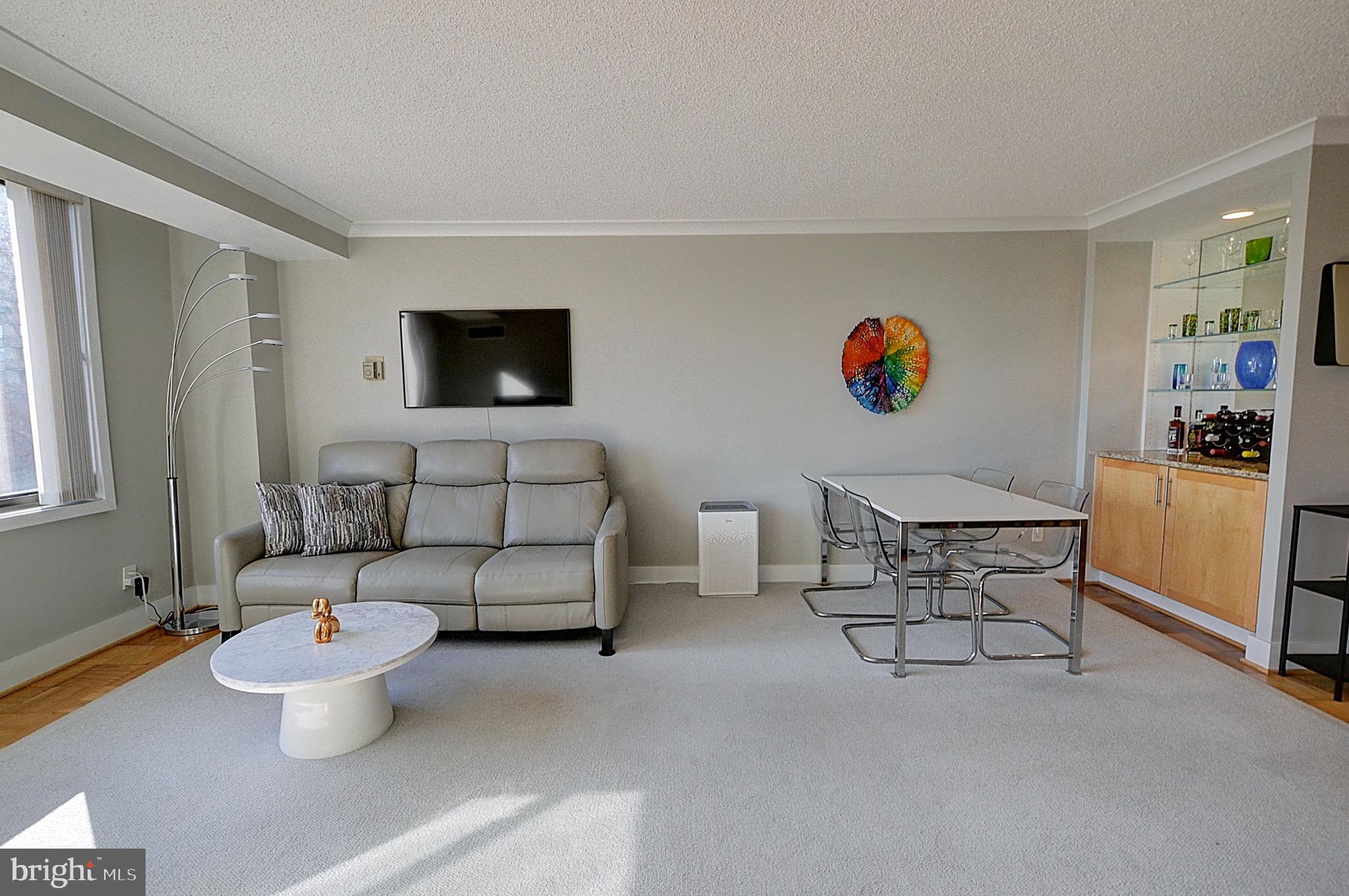 5225 Pooks Hill Road, Unit 121N Bethesda, MD 20814 - Photo 3 of 39 a living room with furniture and a flat screen tv
