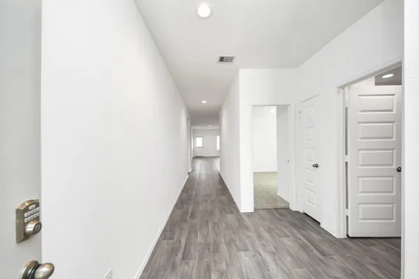 a view of a hallway with wooden floor