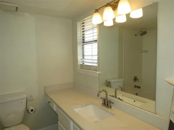 an empty room with a fireplace and windows