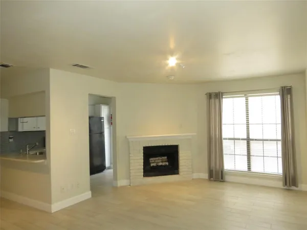 an empty room with windows and fireplace