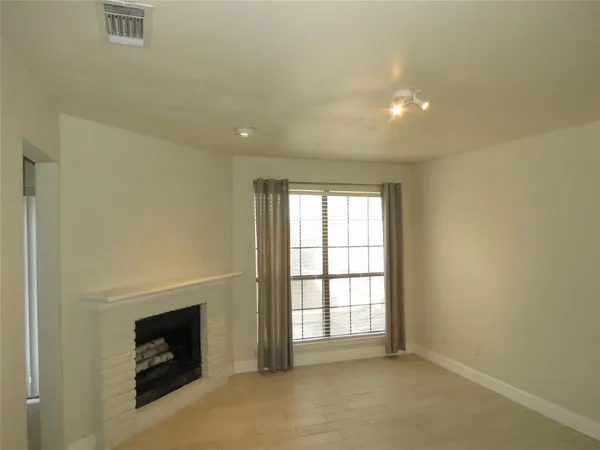 an empty room with a fireplace and windows
