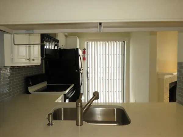 a kitchen with a sink a refrigerator and cabinets