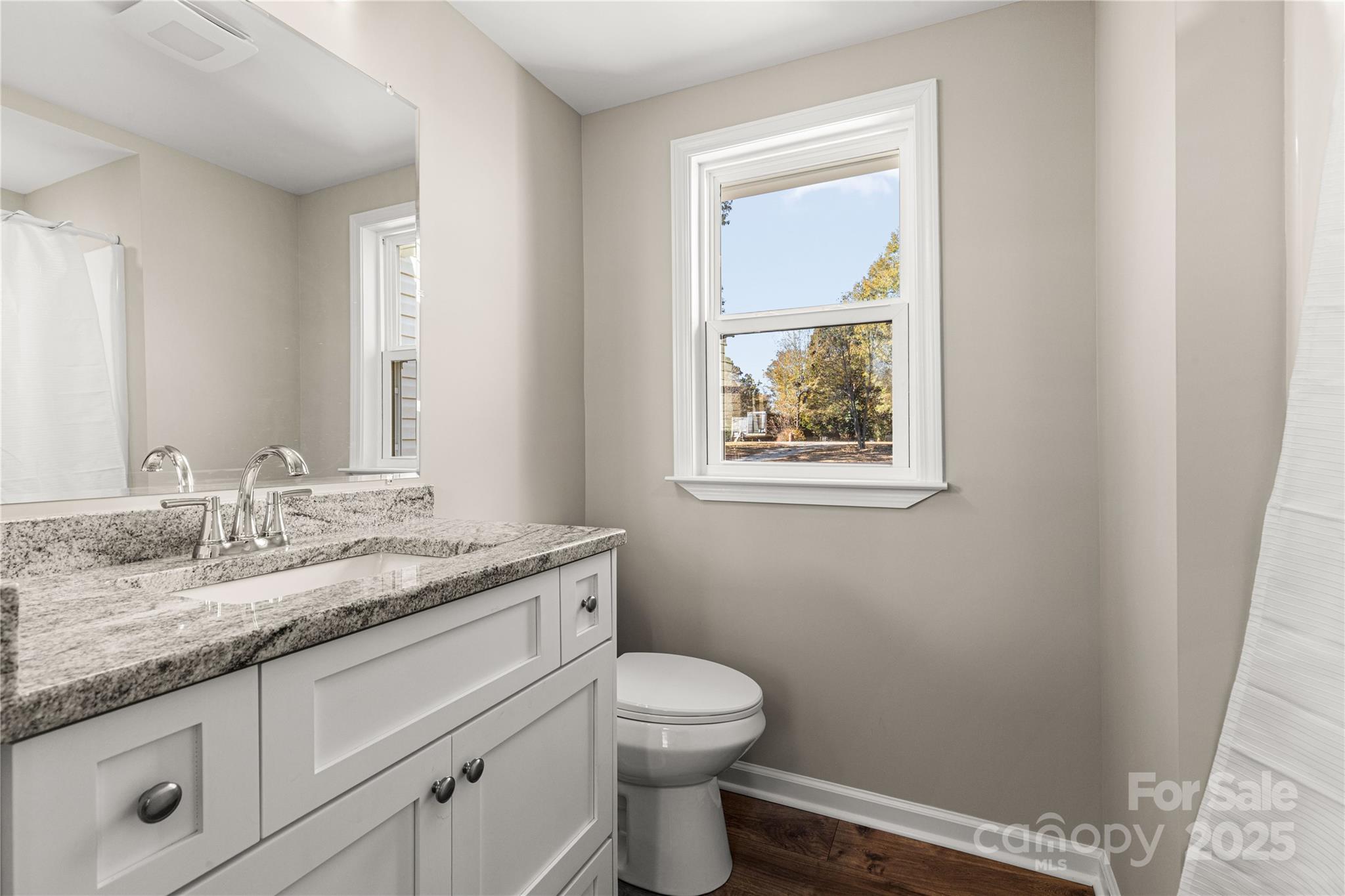 2429 State Rd S-29-746 Lancaster, SC 29720 - Photo 27 of 31 a bathroom with a granite countertop toilet a sink and a window