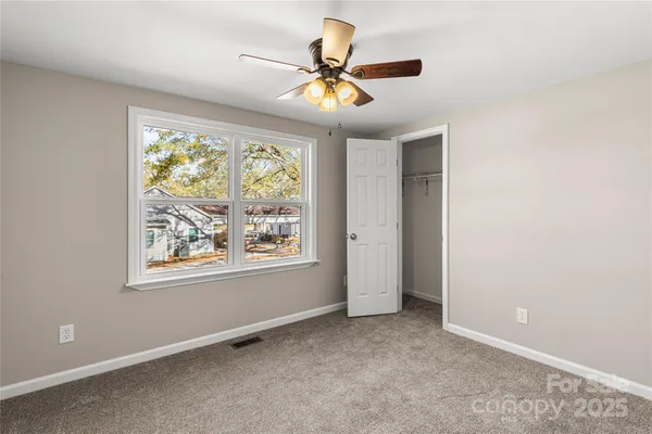 an empty room with chandelier fan