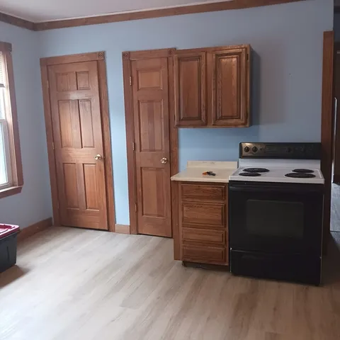 a view of an empty room with closet and a window