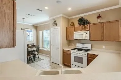 a kitchen with stainless steel appliances a stove a sink cabinets and a refrigerator