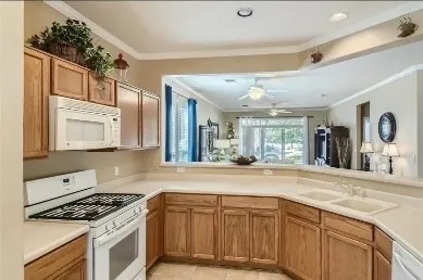 a kitchen with granite countertop a sink stove and cabinets