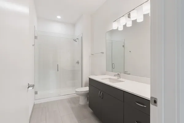 a bathroom with a sink a toilet and shower