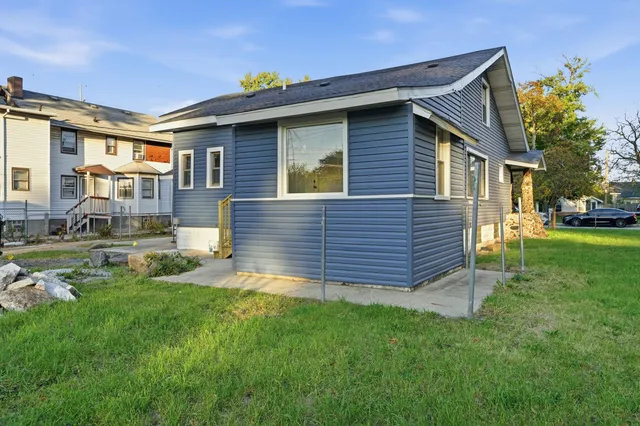 a view of a house with a big yard and large trees