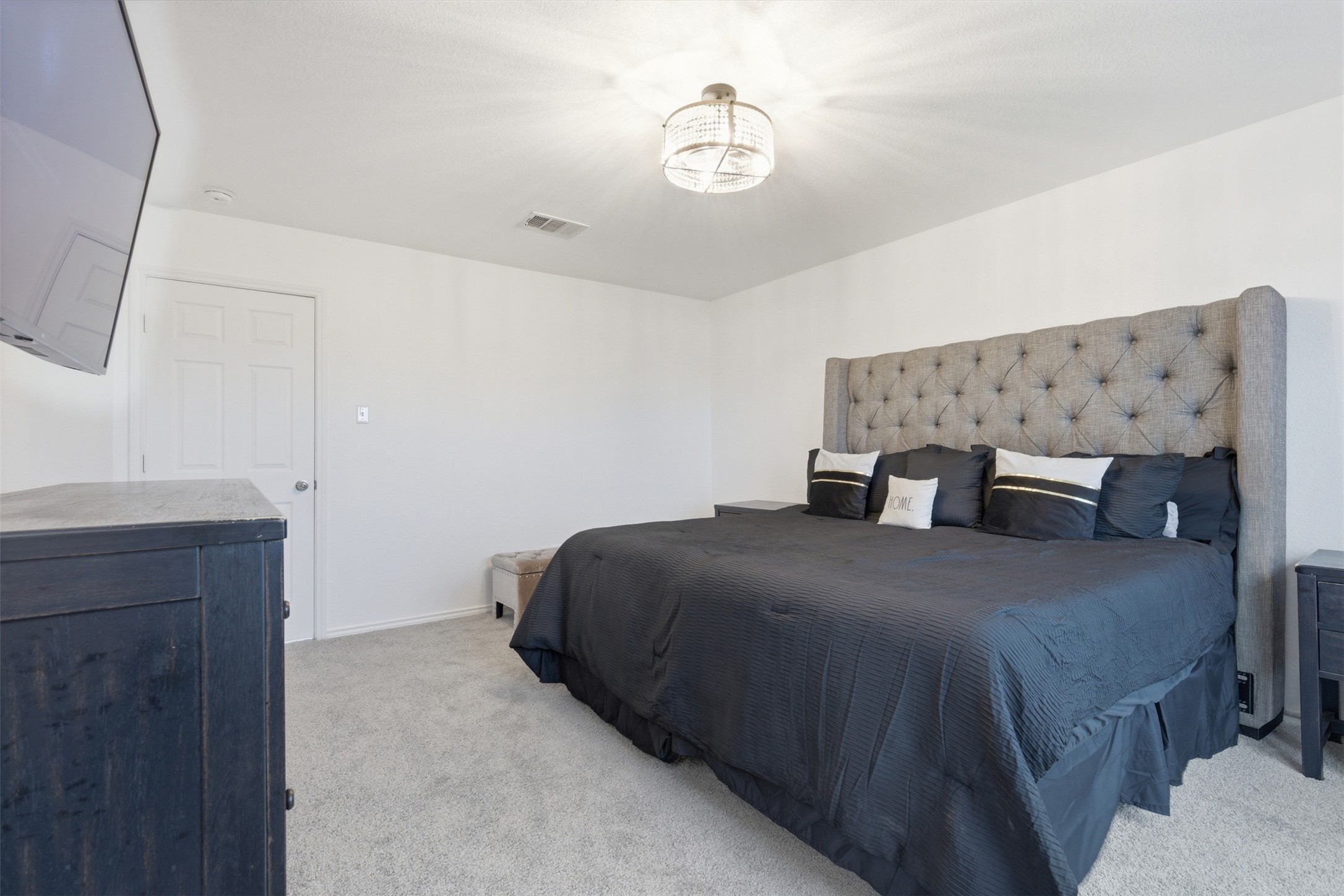101 Magpie Goose Lane Leander, TX 78641 - Photo 12 of 29 a bedroom with a bed and a chandelier