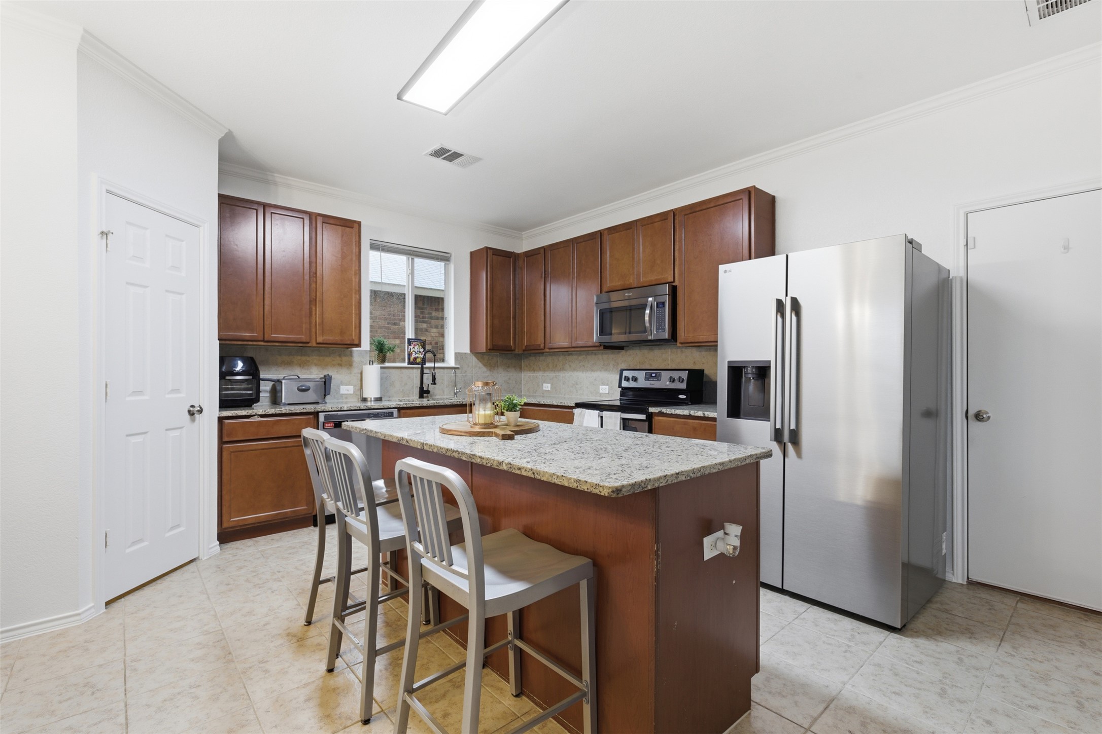 101 Magpie Goose Lane Leander, TX 78641 - Photo 8 of 29 a kitchen with stainless steel appliances granite countertop a refrigerator a stove a sink a dining table and chairs