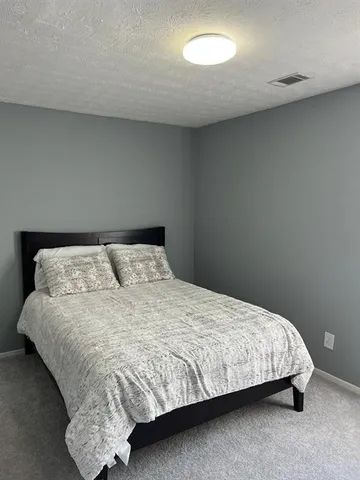 a bedroom with a bed and a night stand