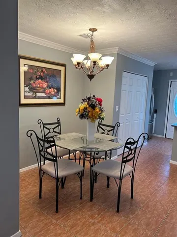 a view of a dining room with furniture and chandelier