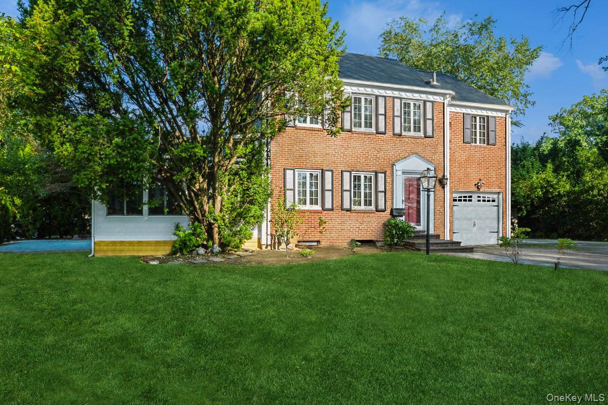 210 Clinton Road Garden City, NY 11530 - Photo 1 of 31 a front view of a house with a yard porch and sitting area