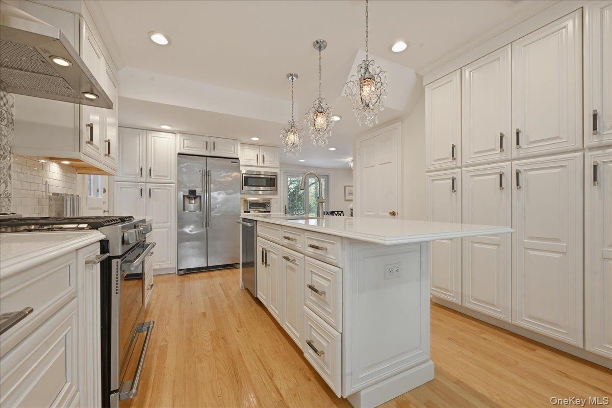 210 Clinton Road Garden City, NY 11530 - Photo 12 of 31 a kitchen with white cabinets and stainless steel appliances