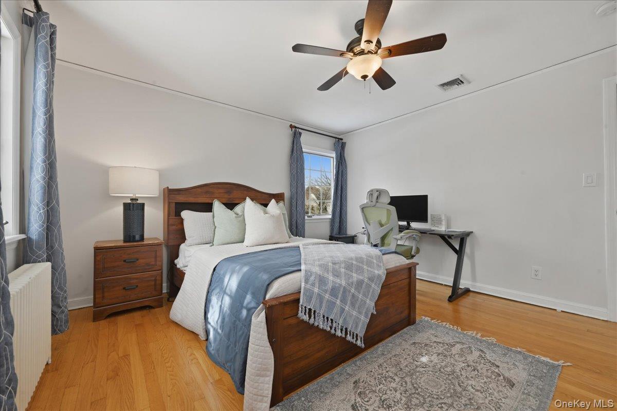 210 Clinton Road Garden City, NY 11530 - Photo 22 of 31 a bedroom with bed and a chandelier