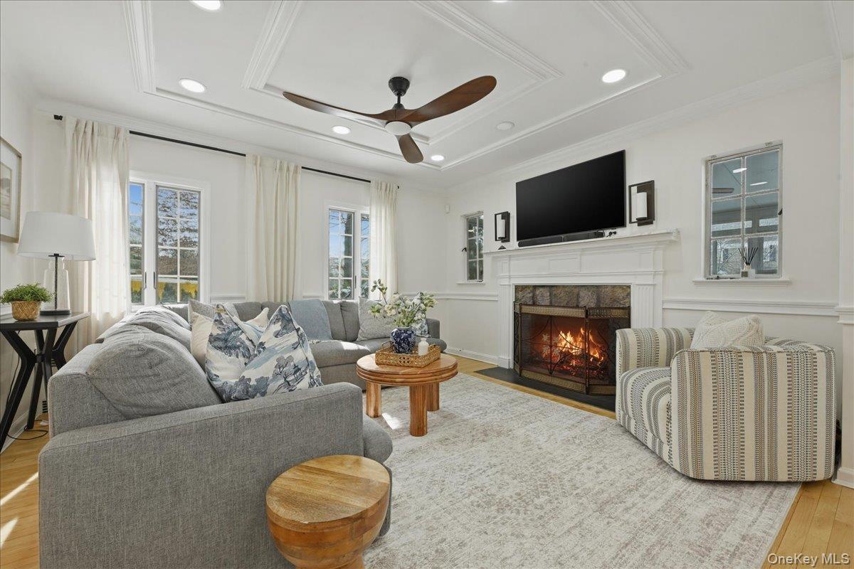 210 Clinton Road Garden City, NY 11530 - Photo 3 of 31 a living room with furniture a fireplace and a flat screen tv