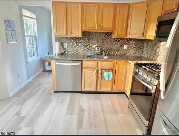 a kitchen with stainless steel appliances granite countertop a refrigerator sink and cabinets