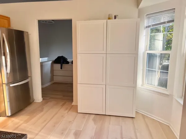 a view of a refrigerator in kitchen and wooden floor