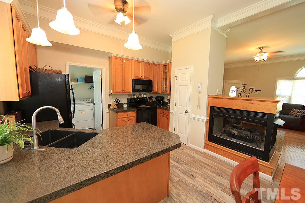 Bright Kitchen open to the Living Room with 3 sided fireplace in the middle.