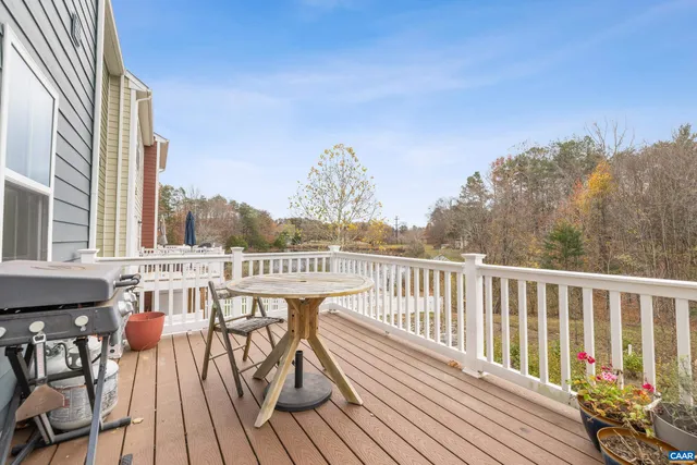 a view of a balcony with wooden floor and outdoor seating