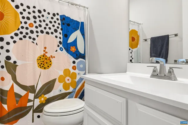 a bathroom with a sink mirror vanity and toilet
