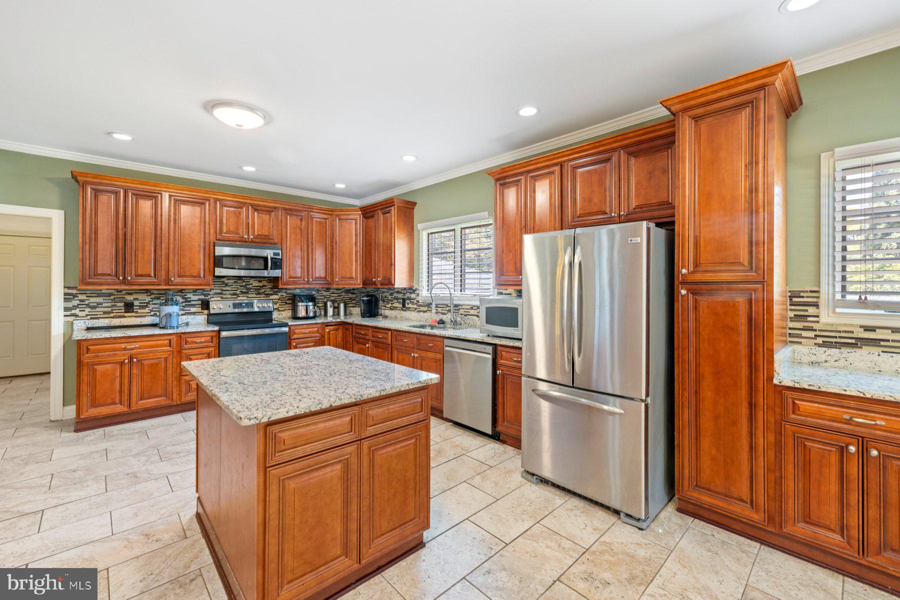 61 Magothy Beach Road Pasadena, MD 21122 - Photo 18 of 63 a kitchen with stainless steel appliances granite countertop a refrigerator stove top oven and large window
