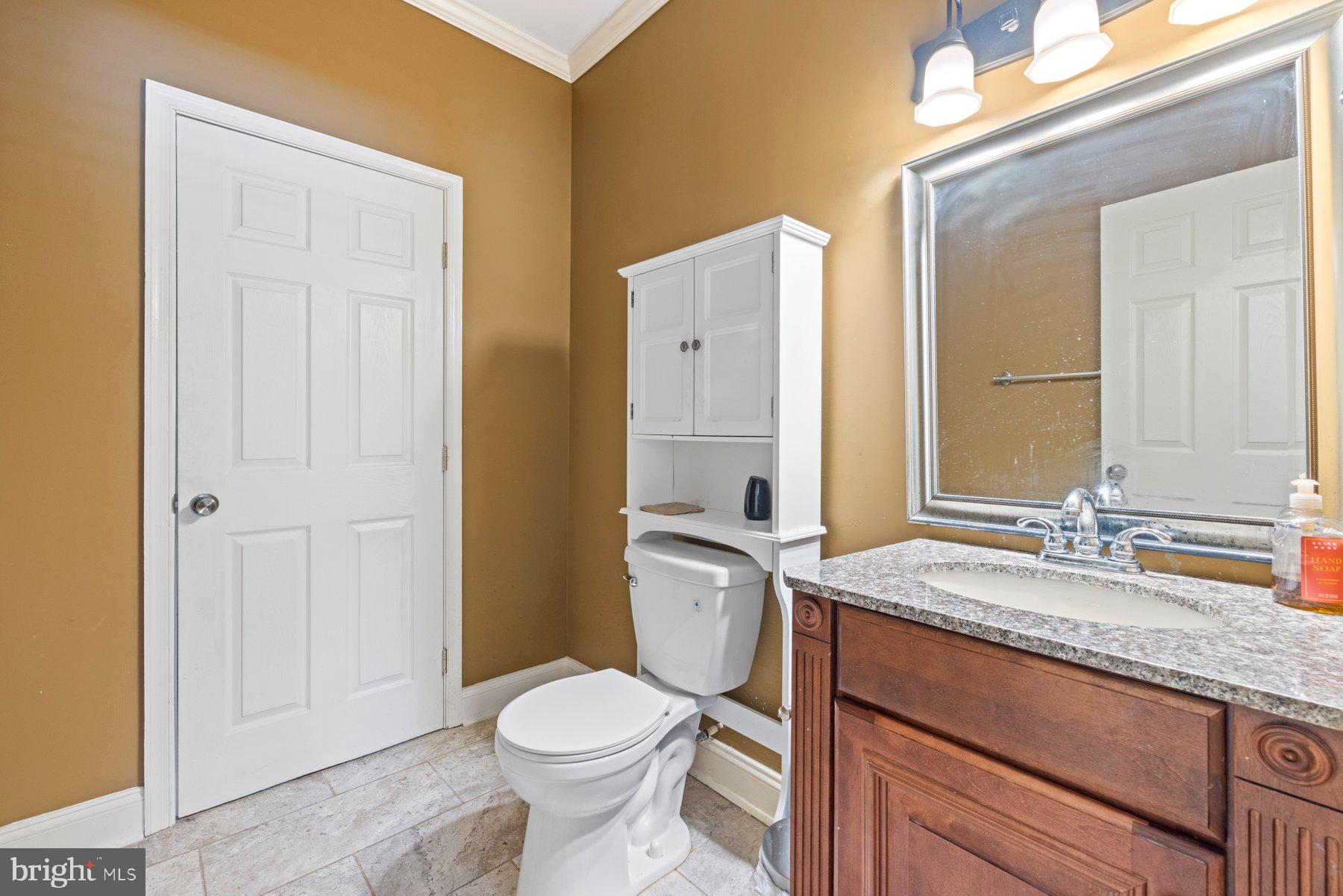 61 Magothy Beach Road Pasadena, MD 21122 - Photo 29 of 63 a bathroom with a granite countertop toilet sink and mirror